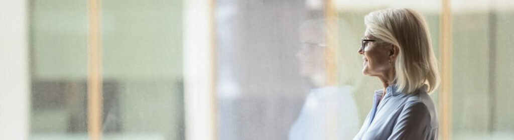 Mature businesswoman looking out a window.