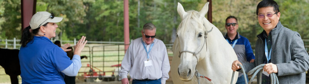 Smiling man leading a horse.